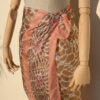 A very soft an elegant shawl in beige color with pink details.