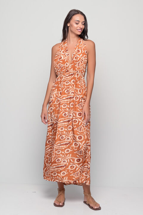 Model wearing Santorini Polymorphic Dress in Dabu Cinnamon print, tied as halter style