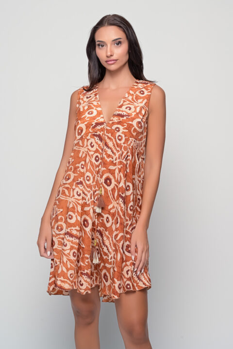Model wearing adjustable Alkeon Dress in Dabu Cinnamon print with tassel tie detail