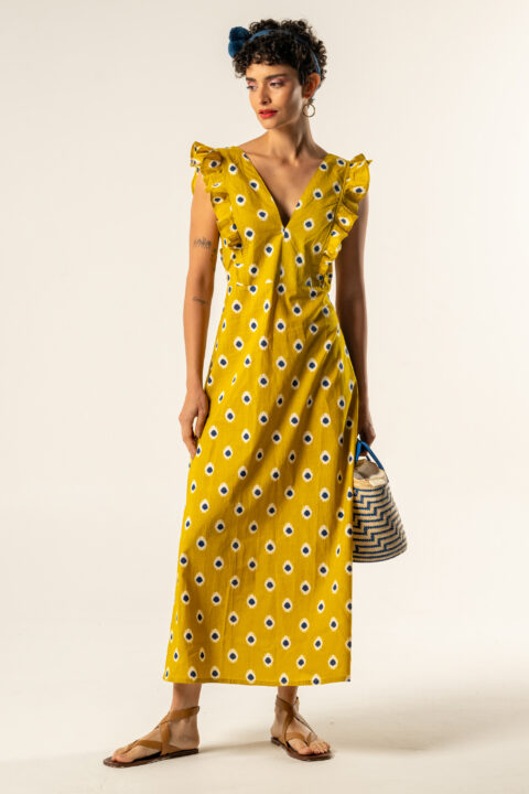 Model wearing Acacia cotton dress in mustard Ikat print with tie-back detail