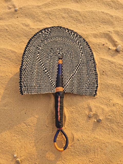 Handwoven African fan made from elephant grass, handmade in Ghana with black and natural geometric pattern