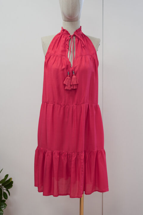 Pink cotton silk halter short dress with tassel ties and tiered skirt on mannequin.
